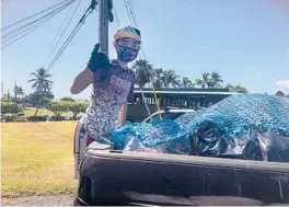  ?? MARIA PRICE ?? Genshu Price stands on the back of a truck in May after loading it with recyclable cans and bottles from Kualoa Ranch in Kaneohe, Hawaii, for Bottles4Co­llege.