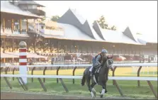  ?? MIKE GROLL — ASSOCIATED PRESS FILE ?? An exercise rider and his horse work out at an empty Saratoga Race Course during a prior meet. The track season opens on Thursday without fans due to the COVID-19 pandemic.