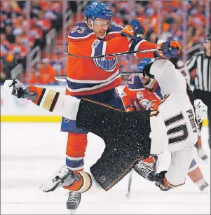  ?? CP PHOTO ?? Edmonton Oilers defenceman Matthew Benning (left) hits Anaheim Ducks right wing Corey Perry during NHL playoff action in Edmonton on Wednesday.