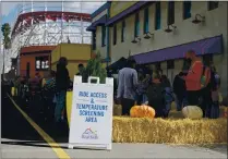  ?? WILLIAM DUNCAN – THE SANTA CRUZ SENTINEL ?? Guests wait in line for temperatur­e screenings at the ride access gate of the Santa Cruz Boardwalk after reopening Saturday.