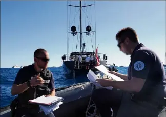  ?? (Photos Jean-Sébastien Gino-Antomarchi) ?? Les agents de la brigade maritime de la police nationale de Menton dressent un procès-verbal d’audition pour un voilier en infraction, ne devant pas mouiller à cet endroit.