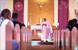  ?? Jessie Wardarski / Associated Press ?? The Rev. Athanasius Abanulo celebrates Mass at Holy Family Catholic Church in Lanett, Ala., on Dec. 12. Originally from Nigeria, Abanulo is one of numerous internatio­nal clergy helping ease a U.S. priest shortage by serving in Catholic dioceses across the country.