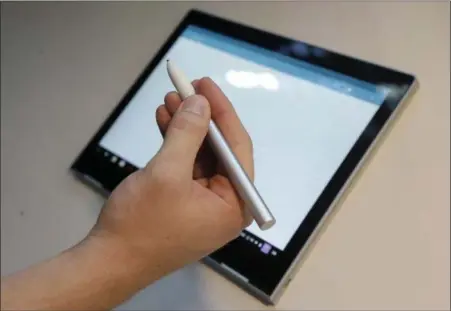  ?? PHOTOS BY JEFF CHIU — ASSOCIATED PRESS ?? A Google employee demonstrat­es a Google Pixelbook Pen at a Google event at the SFJAZZ Center in San Francisco