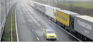  ?? NEIL HALL / EFE ?? Un coche de policía patrulland­o ayer entre camiones camino del puerto de Dover en la autopista M20 en Kent.