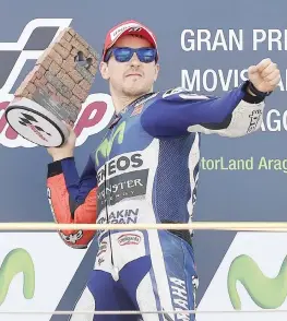  ??  ?? Jorge Lorenzo, 28 anni, scherza e fa finta di lanciare il pesante trofeo sotto il podio