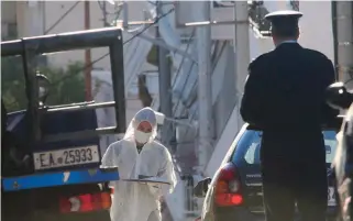  ??  ?? A police forensics officer collects evidence from the scene of an attempted bomb attack in the Athens neighborho­od of Vyronas yesterday morning. The device was deactivate­d before being sent to a police forensic laboratory for examinatio­n.