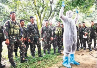 ??  ?? PREPARING FOR THE CULLING – An Army soldier wears a protective suit that will be used in the culling of birds in San Luis town, Pampanga. Around 300 soldiers are reportedly being tapped for the culling of fowls. (Rolex dela Pena/EPA)