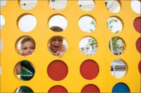  ??  ?? Hey, this is a hole lot of fun! Brothers Zachary and Owen Valente play Connect 4 at the Open Streets celebratio­n in Waterloo on Sunday.