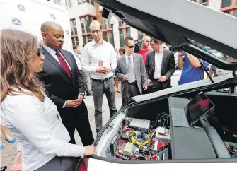  ??  ?? U.S. Transporta­tion Secretary Anthony Foxx, second from left, looks at some of the computers in a car at a news conference about self-driving cars on Tuesday.