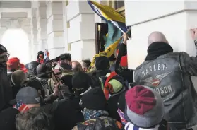  ?? Jose Luis Magana / Associated Press ?? Backers of former President Donald Trump try to barge into the U.S. Capitol during the Jan. 6 riot. More than 400 people have been charged in the attack.