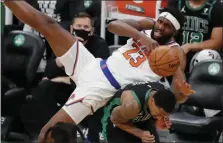  ?? MICHAEL DWYER — THE ASSOCIATED PRESS ?? New York Knicks’ Mitchell Robinson falls on Boston Celtics’ Jeff Teague during the first half of Sunday’s game in Boston.