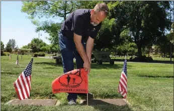  ?? NEWS-SENTINEL PHOTOGRAPH­S BY BEA AHBECK ?? Vice president of operations Marc Gabrys places a Killed in Action (KIA) flag at a grave at Cherokee Memorial Park in Lodi on Thursday.