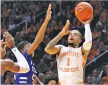  ?? AP PHOTO/TOM SHERLIN ?? Tennessee’s Lamonte’ Turner (1) shoots a short left-handed shot in the lane while defended by UNC Asheville’s Trent Stephney. Turner scored 17 points as Tennessee won 78-63.