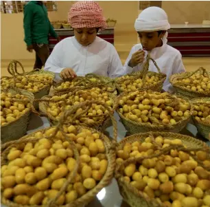  ?? Photos by Ryan Lim ?? Emirati children try fresh ratab dates during the Liwa Dates Festival. Dates from both renowned dates farms to new ones are on display at the biggest festival of its kind. —