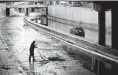  ?? Marvin Pfeiffer / Staff photograph­er ?? An SAPD officer shovels mud off of Interstate 35 on Saturday under San Pedro Avenue.