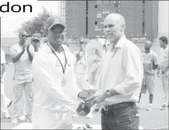  ?? Charles photo) (Orlando ?? Jaguars skipper Leon Johnson is presented with the George Headley & Sir Everton Weekes trophy by Cricket West Indies’ Jimmy Adams