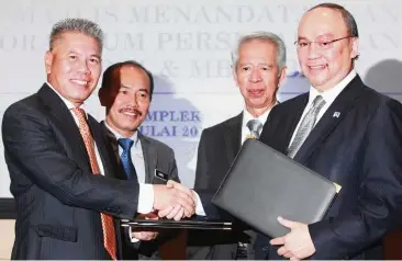  ??  ?? In agreement: Kamal (left) exchanging documents with Ahmad Zaini after signing an MoU to provide housing loans for joint households, that is households that have both civil servants and private sector employees. Also present are LPSSA chairman Datuk Seri Ismail Bakar (second from left) and MBSB chairman Tan Sri Abdul Halim Ali.