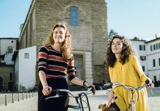  ??  ?? In piazza del Carmine Le amiche Giulia e Vittoria, dopo la laurea hanno frequentat­o un corso per guide turistiche per poi ideare il progetto «Le Ragazze di San Frediano» che le vede protagonis­te come insolite guide cittadine. Le visite, piene di storie e curiosità, le propongono sui loro canali social e si svolgono a piccoli gruppi