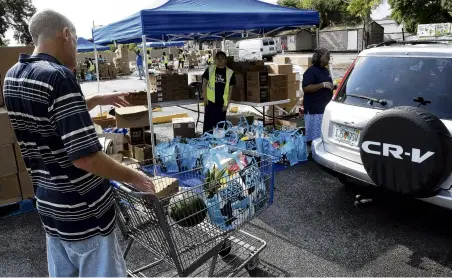  ?? PHOTO: GETTY IMAGES ?? Deprivatio­n . . . A man receives food items in a shopping cart at a food distributi­on event for the needy sponsored by the Second Harvest Food Bank of Central Florida and Orange County at St John Vianney Church in Orlando.