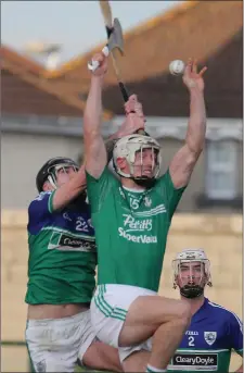  ??  ?? Cathal Dunbar (Naomh Eanna) leaps into the air in search of possession with Jack Fenlon (Glynn-Barntown) breathing down his neck.