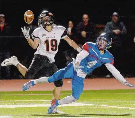  ?? DANA JENSEN/THE DAY ?? Montville’s Marcus Velez (19) catches a long pass against Waterford’s Niko Thibeault (4) after the ball was tipped in the air during Thursday’s high school football game at Waterford. Waterford won 37-19, its first victory on its home field in two seasons. Go to www.theday.com to view Dana Jensen’s photo gallery from the game.