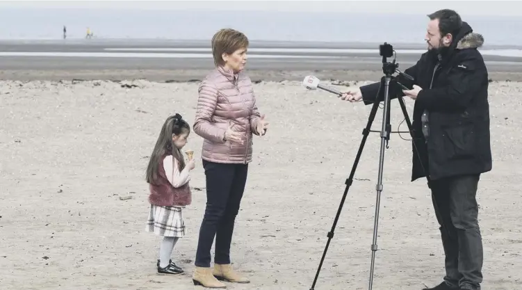  ??  ?? 0 First Minister Nicola Sturgeonst­ands with Scarlett, the daughter of SNP candidate Siobhian Brown, as she speaks during a radio interview in Ayr, South Ayrshire, during election campaignin­g