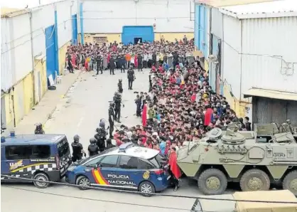  ?? Foto: Efe ?? Policía Nacional y Ejército vigilan a un gran grupo de personas provenient­es de Marruecos.