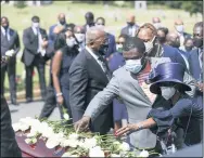  ?? ALYSSA POINTER/ATLANTA JOURNAL-CONSTITUTI­ON VIA AP ?? Family members place flowers on the casket of Rep. John Lewis during the burial service at South-View Cemetery in Atlanta July 30.