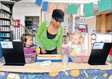  ?? Don Lee Los Angeles Times ?? THE MEDIAN HOURLY WAGE for child-care workers is $9.77, about $3 below the average janitor’s. Above, Asiya Jabbaar, an early childhood education teacher in Oakland, works with kids at her child-care center.