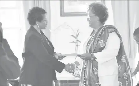  ??  ?? Prime Minister Mia Mottley (right) receiving the instrument of office from Governor General Dame Sandra Mason.