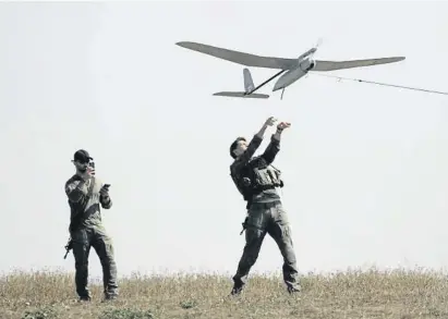  ?? Amir Levy / Getty ?? Soldados israelíes levantan un dron cerca de la frontera con Gaza