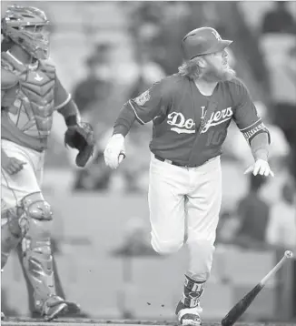  ?? Mark J. Terrill Associated Press ?? JUSTIN TURNER of the Dodgers watches the path of his two-run home run in the bottom of the first inning as Angels catcher Martin Maldonado also keeps an eye on it.