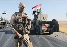  ??  ?? Iraqi security forces gather last week outside the Kurdish-held city of Altun Kupri on the outskirts of Irbil, Iraq.