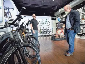  ?? MAX GERSH/THE COMMERCIAL APPEAL ?? Store manager and fitting specialist Sean Vandergrif­f, left, talks with Jeff Goldstein about e-bikes Tuesday at Victory Bicycle Studio in Memphis.