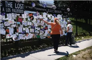  ?? SPENCER PLATT
GETTY IMAGES ?? People walk by a memorial for those who have died from the coronaviru­s outside Green-Wood Cemetery on Wednesday in Brooklyn, N.Y.