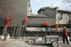  ?? — Reuters ?? Workers fix a brick wall in the traditiona­l style in Beijing.