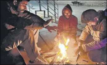  ?? WASEEM ANDRABI/HT ?? Locals warm themselves on a chilly evening in Srinagar.