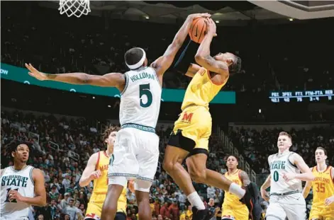  ?? AL GOLDIS/AP ?? Michigan State guard Tre Holloman (5) blocks a shot by Maryland guard Jahmir Young during the first half Saturday in East Lansing, Michigan.