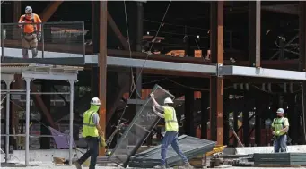  ?? AP file ?? BACK AT IT: Workers build a protective barrier as constructi­on resumed on the New York Islanders’ new arena during the current coronaviru­s outbreak on Wednesday in Elmont, N.Y. While some return to work, the debate over extending unemployme­nt benefits goes on.