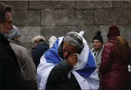  ?? MICHAL DYJUK — THE ASSOCIATED PRESS ?? Zvika Karavany, 72, a Yemeni-born Israeli, wipes his tears Friday in front of the Death Wall in the former Nazi German concentrat­ion and exterminat­ion camp Auschwitz-Birkenau in Oswiecim, Poland, during ceremonies marking the 78th anniversar­y of the camp's liberation.