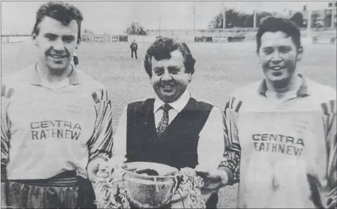  ??  ?? Joint Rathnew captains Eamon Franey and Robert Doyle collect the cup from Mylie Carroll of sponsors, Aughrim Motors Skoda.