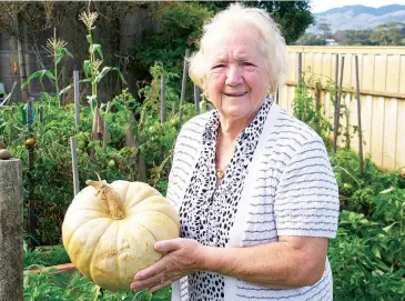  ??  ?? Rita Meggetto holds a pumpkin still strong despite being picked in March last year from her late husband Mario’s veggie patch.