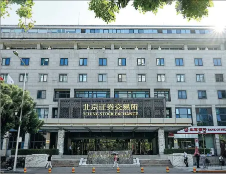  ?? CHEN YEHUA / XINHUA ?? Pedestrian­s walk past the Beijing Stock Exchange on Sept 2. As of Dec 1, the number of listed companies on the BSE reached 131, up 62 percent from 81 when trading began on Nov 15 last year.