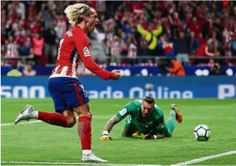  ?? — Reuters ?? Slick striker: Atletico Madrid’s Antoine Griezmann celebratin­g after scoring against Malaga at the Wanda Metropolit­ano on Saturday. Atletico won 1- 0.