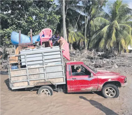  ??  ?? Arbeiter einer Bananenfar­m in Honduras auf der Flucht vor dem Tropenstur­m Iota