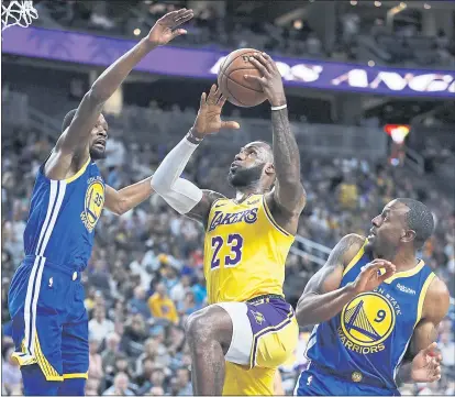  ?? JOHN LOCHER — THE ASSOCIATED PRESS ?? LeBron James is surrounded by Kevin Durant, left, and Andre Iguodala in his first game against the Warriors as a Laker.