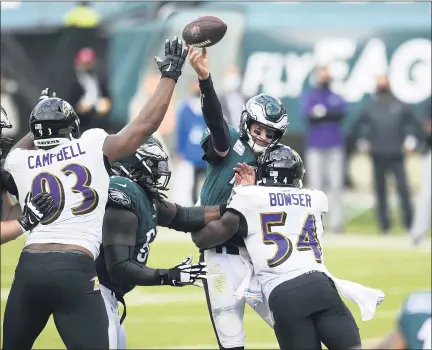  ?? DERIK HAMILTON — THE ASSOCIATED PRESS ?? Philadelph­ia Eagles’ Carson Wentz (11) tries to pass against Baltimore Ravens’ Tyus Bowser (54) and Calais Campbell (93) during the second half of an NFL football game, Sunday, Oct. 18, 2020, in Philadelph­ia.