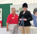  ??  ?? Ellie Hull being presented her rosette for second place in Class 78 Countrysid­e challenge.