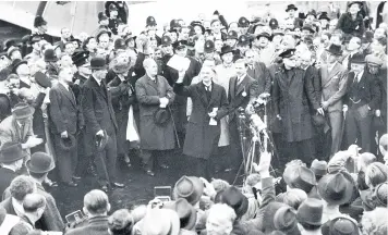  ??  ?? Prime Minister Neville Chamberlai­n holding aloft the AngloGerma­n Declaratio­n to the cheering crowd who greeted him on arrival at Heston Airport on 30 September 1938; right, ships holding position off the beaches at Dunkirk and smoke billowing from burning oil storage tanks, deliberate­ly ignited by the fleeing Allies to prevent such a useful resource falling into German hands