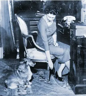  ?? ABOVE: AFP / GETTY IMAGES. BELOW: UPI SLIDE ?? Queen Elizabeth II is pictured above in 1959 at her office with her dog Susan, one of the more than 30 Corgis she has owned. Right, the Queen at Balmoral Castle with a Corgi by her side in 1953.